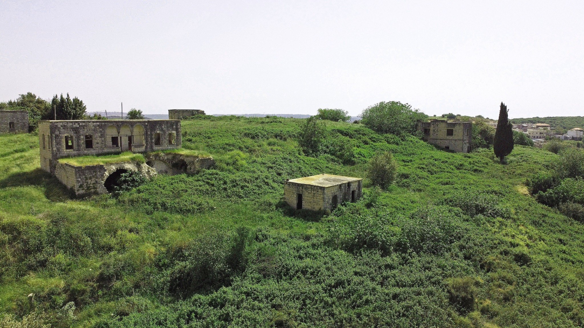 Aerial landscape of Dayr al-Qasi with surviving houses