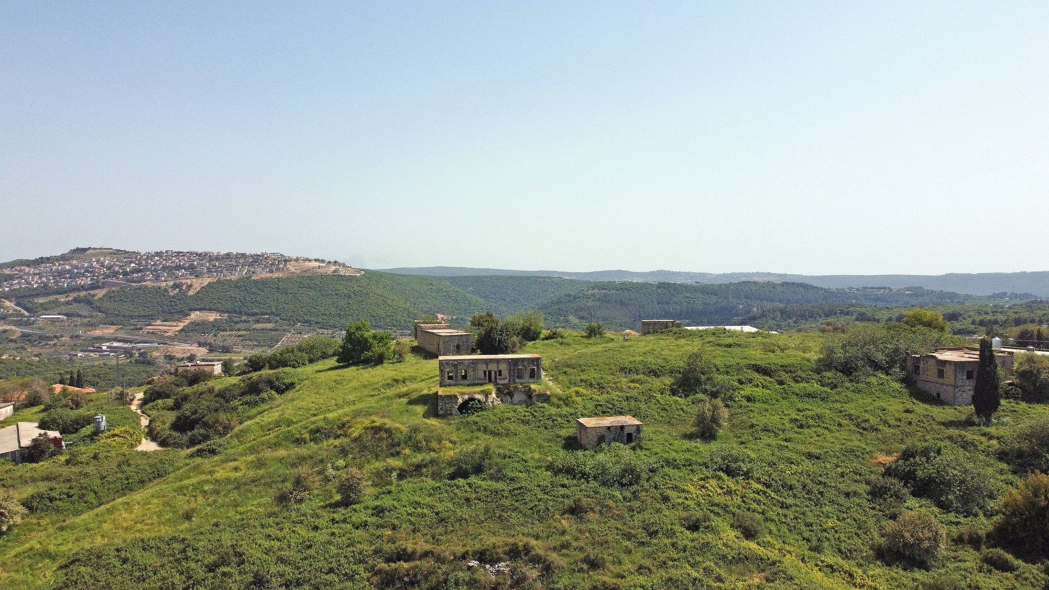 Wide view of Dayr al-Qasi and a surviving family house